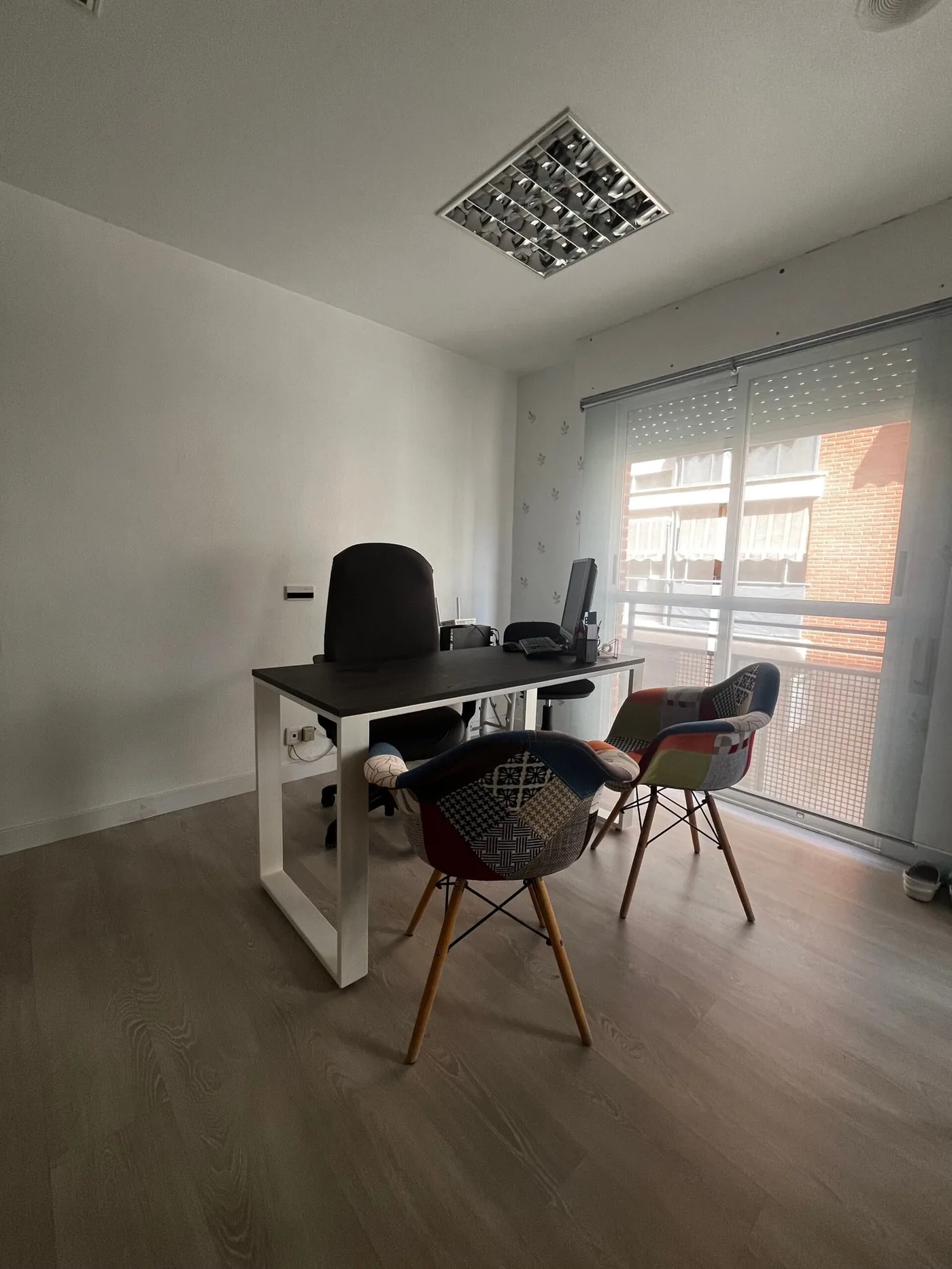 Sala de consulta con mesa y sillas junto al ventanal