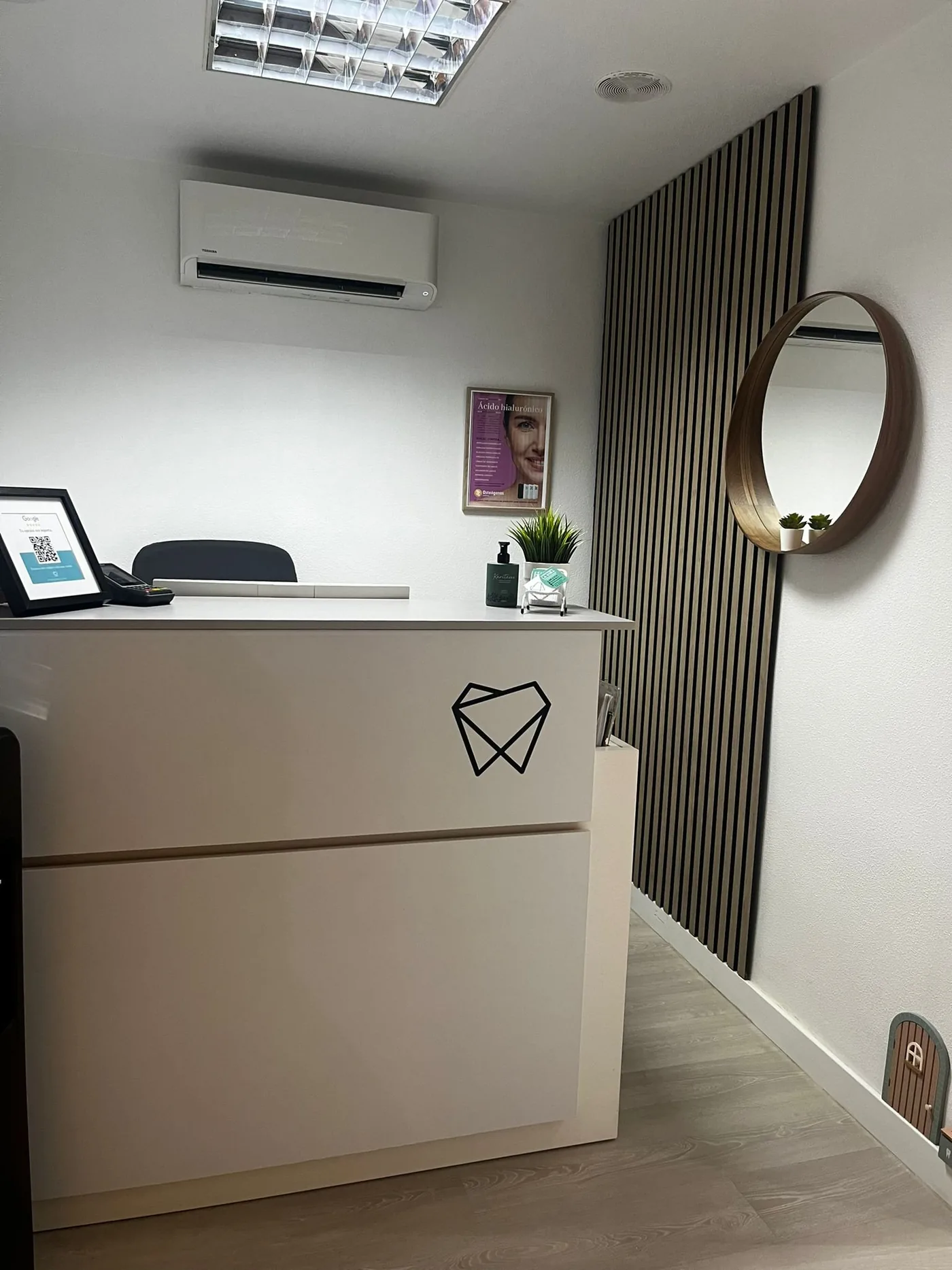 Mostrador de recepción de la clínica, con el logo del diente grabado en el frontal