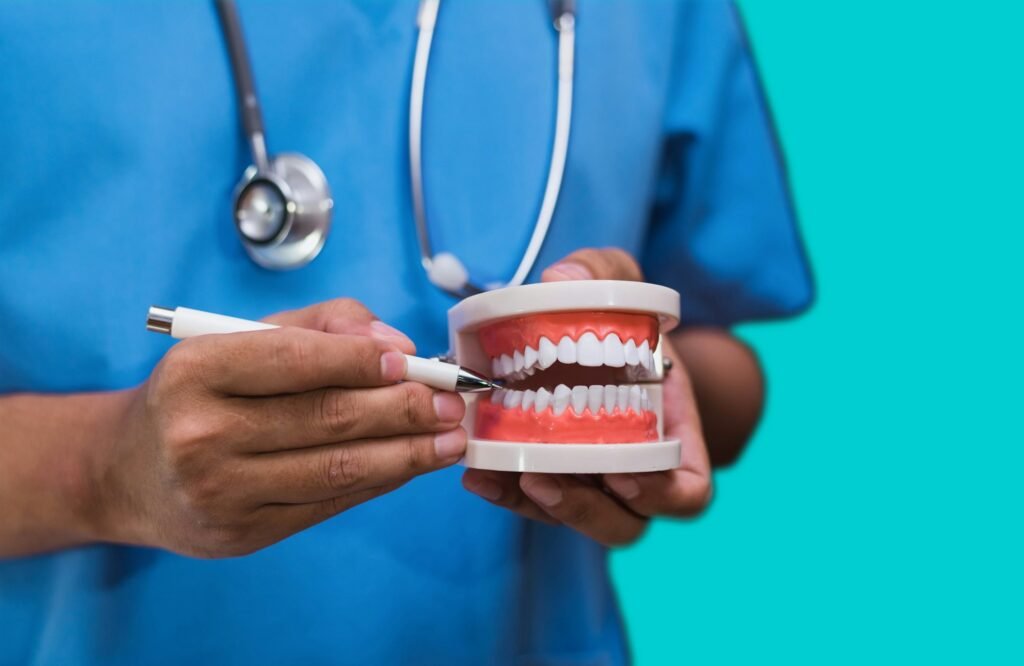 Stomatologist gives recommendations and shows the patient the procedure for dental treatment on the